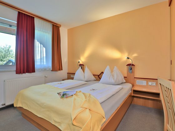 Doppelbett im Appartement Family im Hotel Garni Zerza.