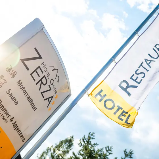 Schild und Fahne an der Einfahrt vom Hotel Garni Zerza.